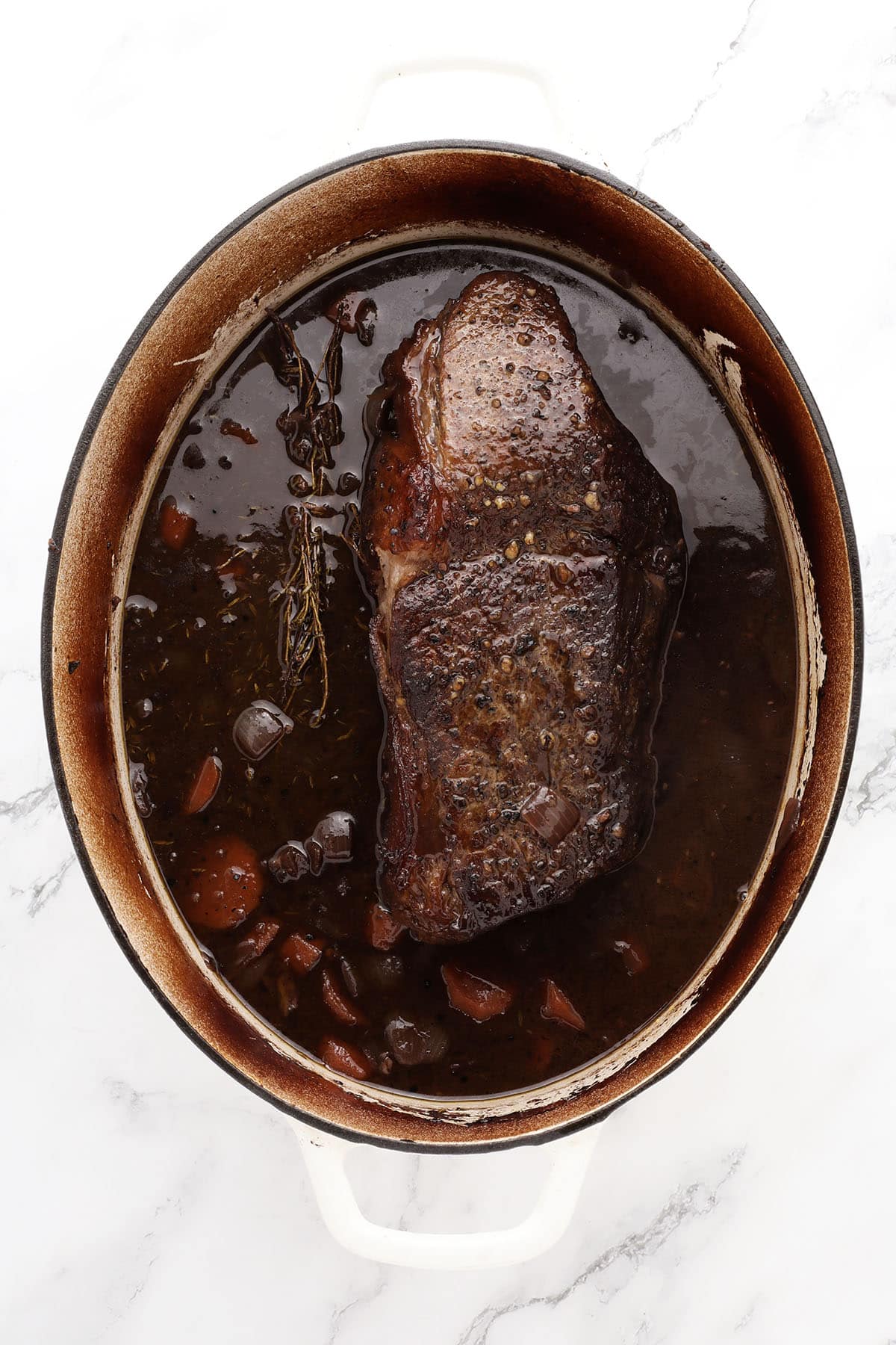 Tender chuck roast with red wine sauce and thyme garnish