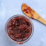 overhead shot of rosemary fig jam in a jar with a wooden knife