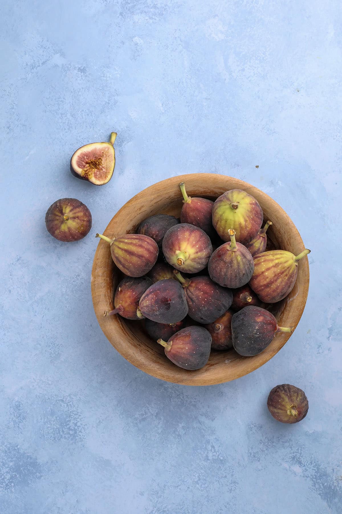 overhead shot of a wooden bowl filled with fresh figs