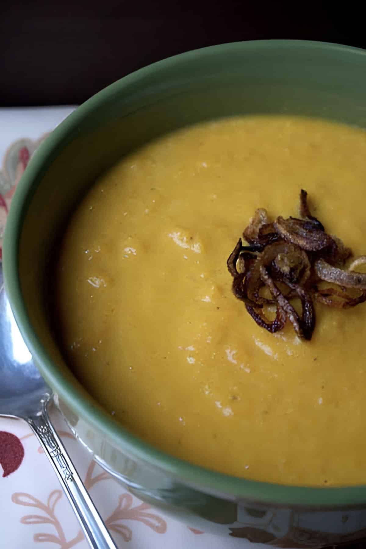 Bowl of Curried Carrot and Apple Soup with crispy fried shallots on top