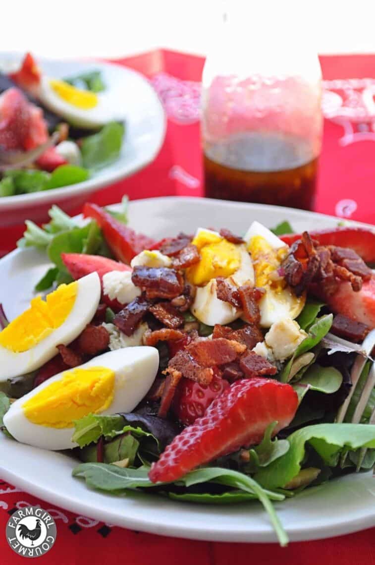 spring salad with strawberries bacon and bleu cheese on a plate