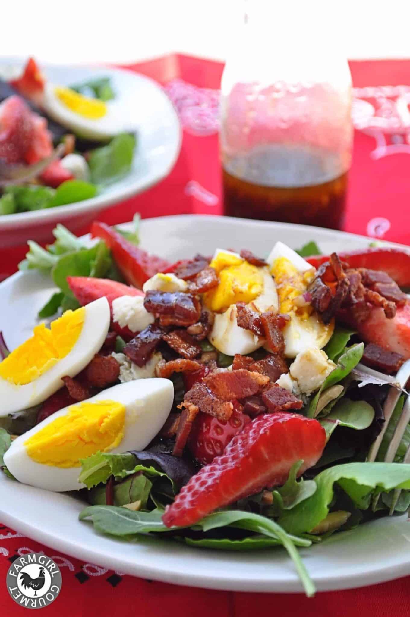 spring salad with strawberries bacon and bleu cheese on a plate