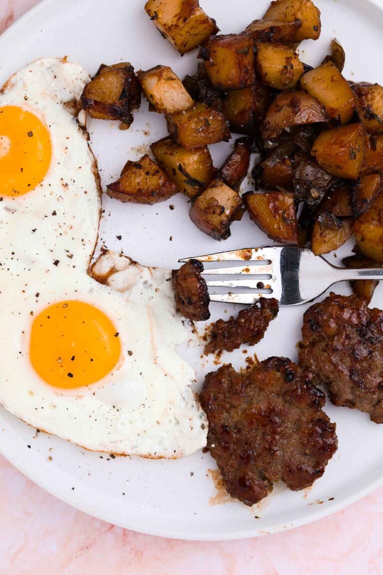 close-up of maple brown sugar breakfast potatoes on a plate with eggs and potatoes