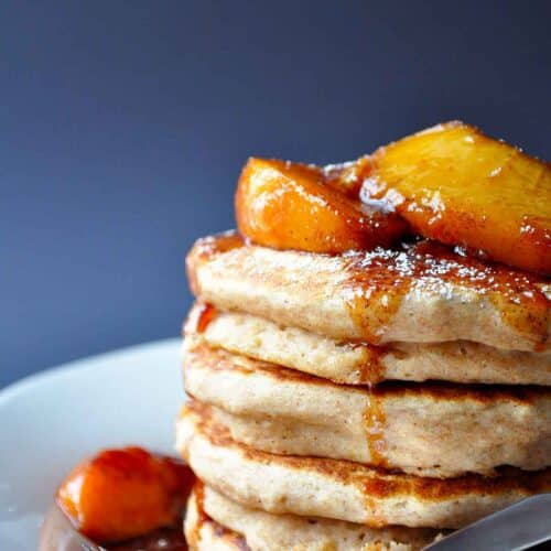 applesauce pancakes on a plate with fresh peach compote on top