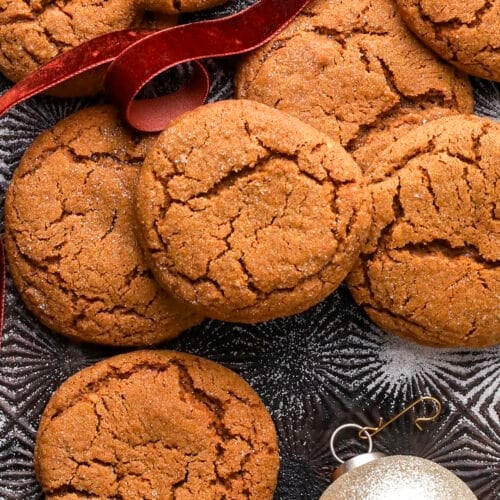 molasses cookies with crinkled tops on a baking sheet.