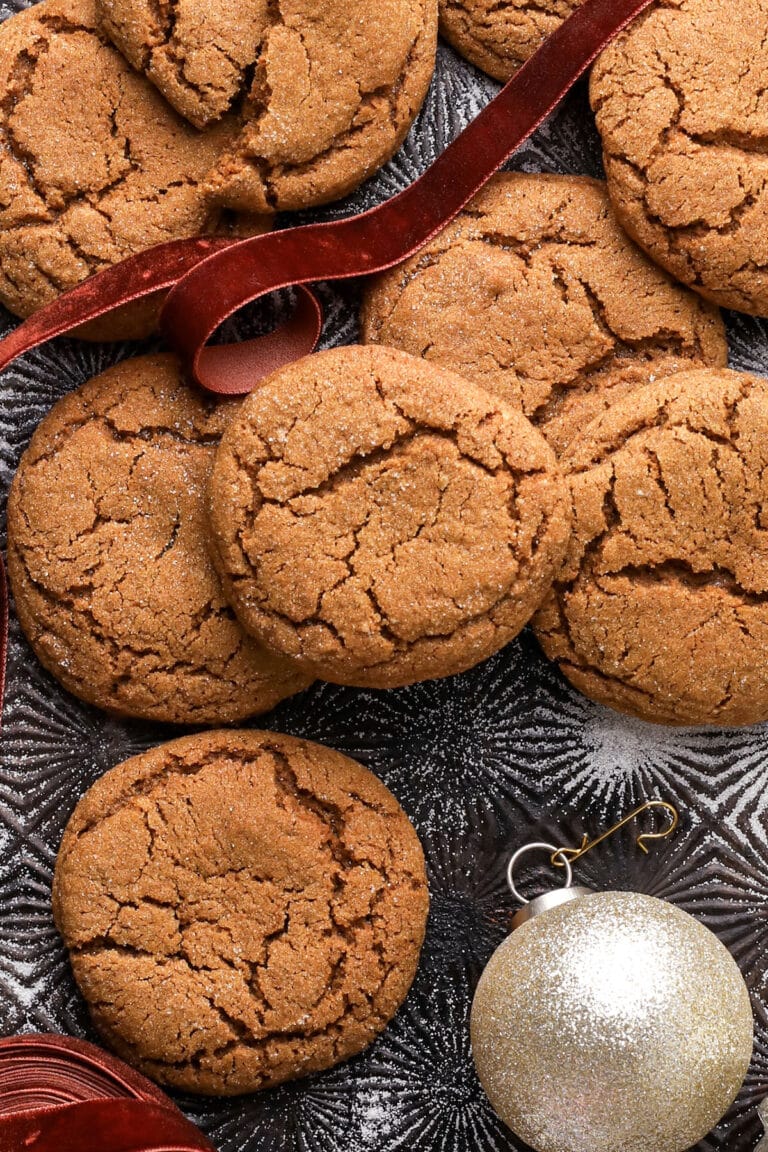molasses cookies with crinkled tops on a baking sheet.