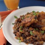 spicy chicken thighs on a bead of chorizo black beans