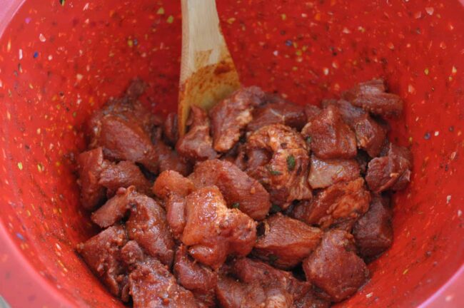 Season cut up pork shoulder with spices and seasonings