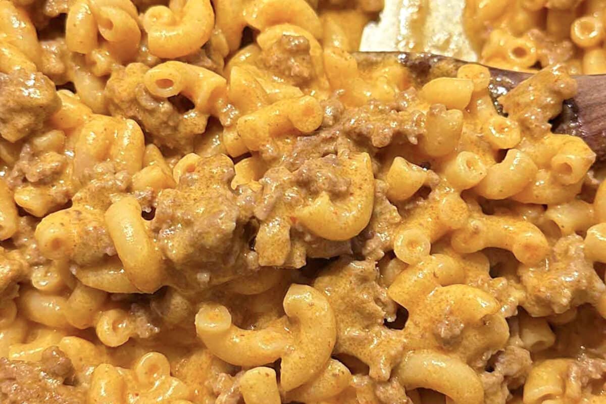 Close-up of creamy macaroni and cheese mixed with ground beef, spiral pasta coated in a rich, orange sauce with chunks of meat—this homemade hamburger helper makes an easy weeknight dinner everyone will love.