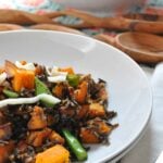 close up of pumpkin and wild rice salad on a white plate