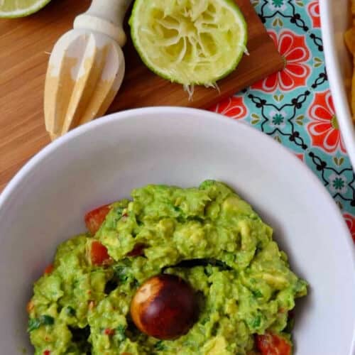 top down view of classic guacamole in a bowl with lime