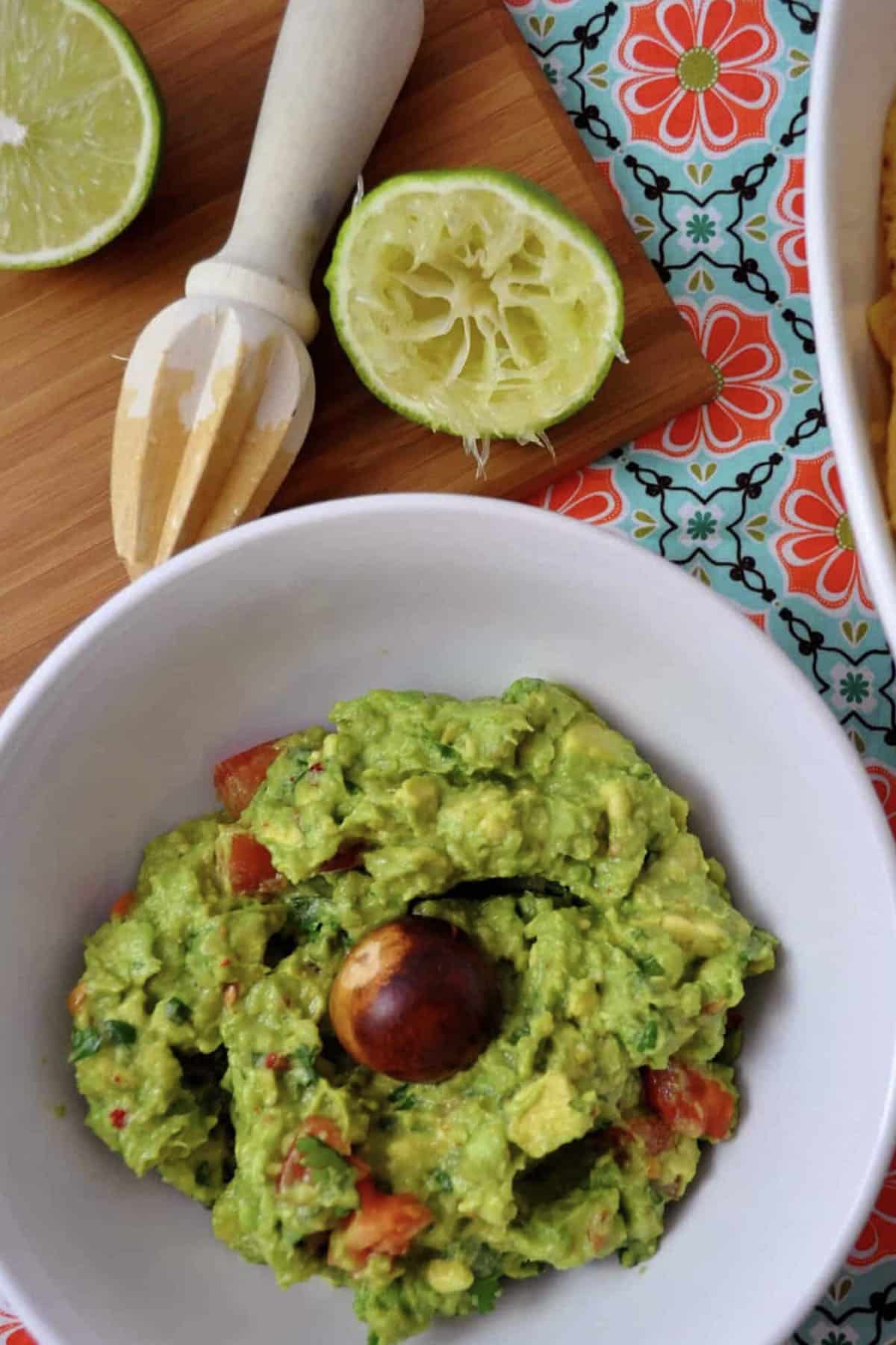 top down view of classic guacamole in a bowl with lime