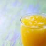 glass of mango orange agua fresca with ice