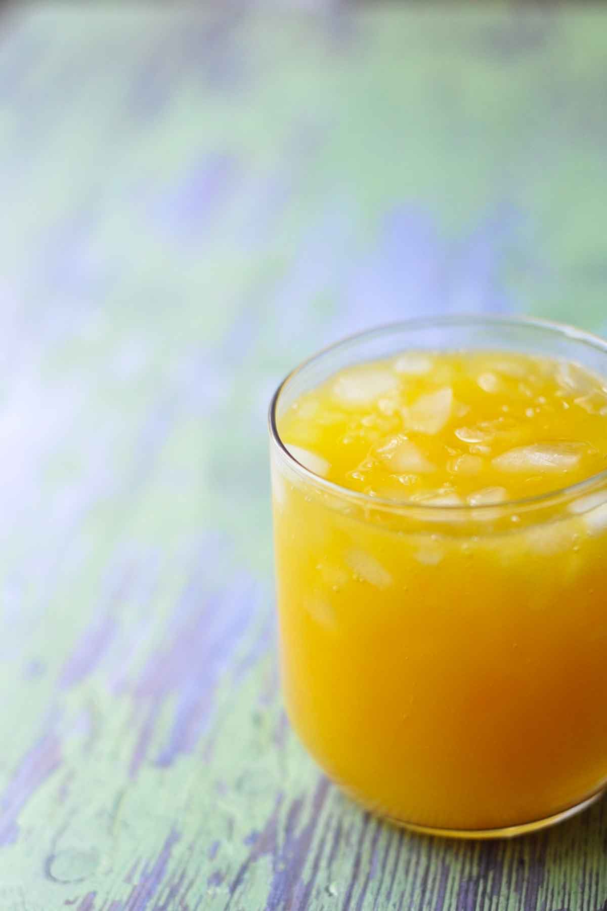glass of mango orange agua fresca with ice