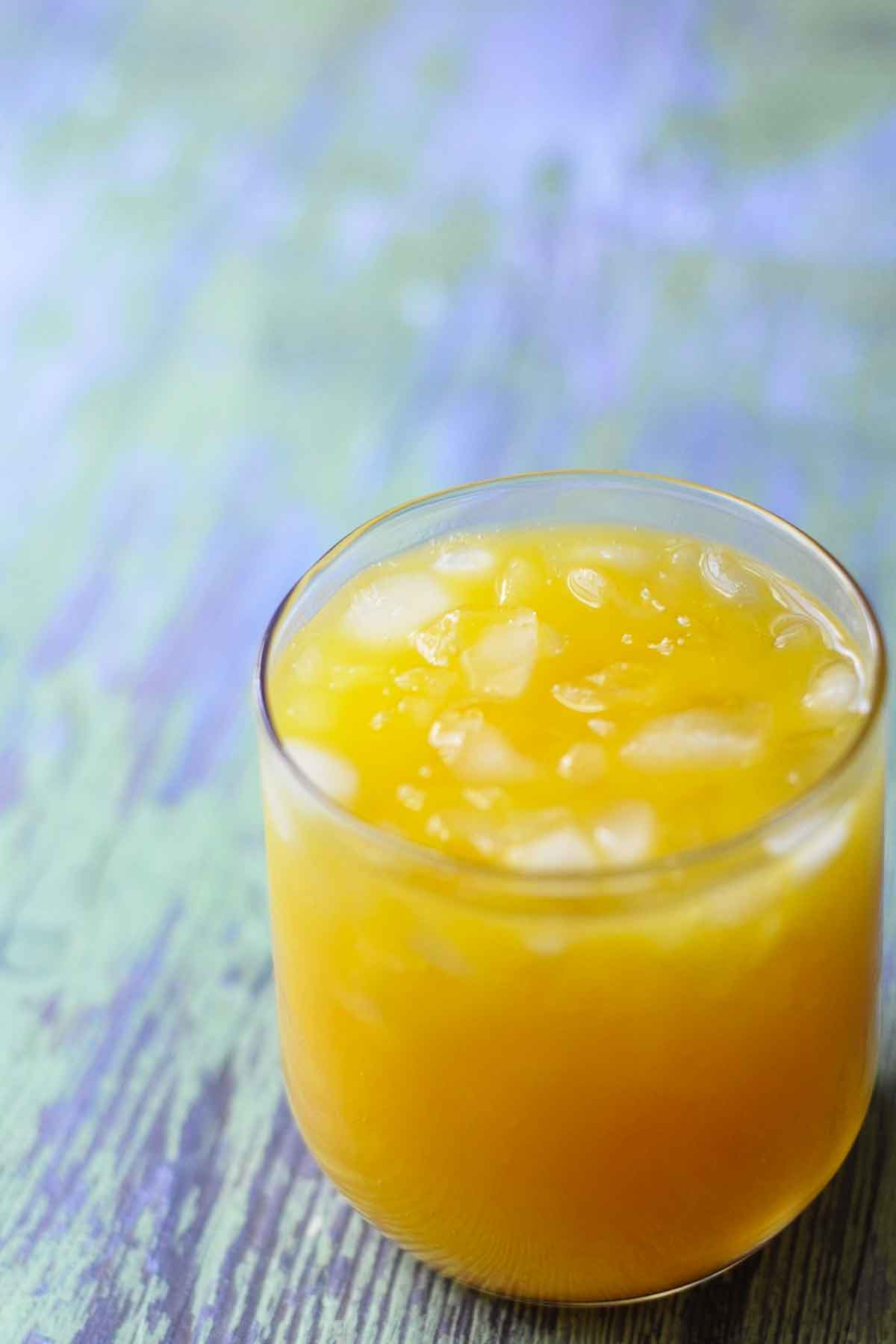 Refreshing mango orange summer drink served with ice