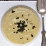 a bowl of creamy sweet potato soup with fried sage topping