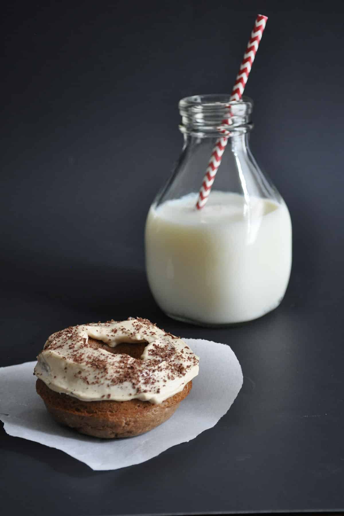 closeup of a kahlua and cream donut with a jug of milk
