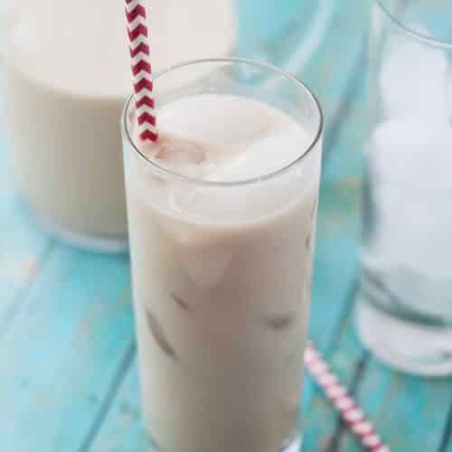 closeup of a tall glass of cashew horchata with ice and a straw