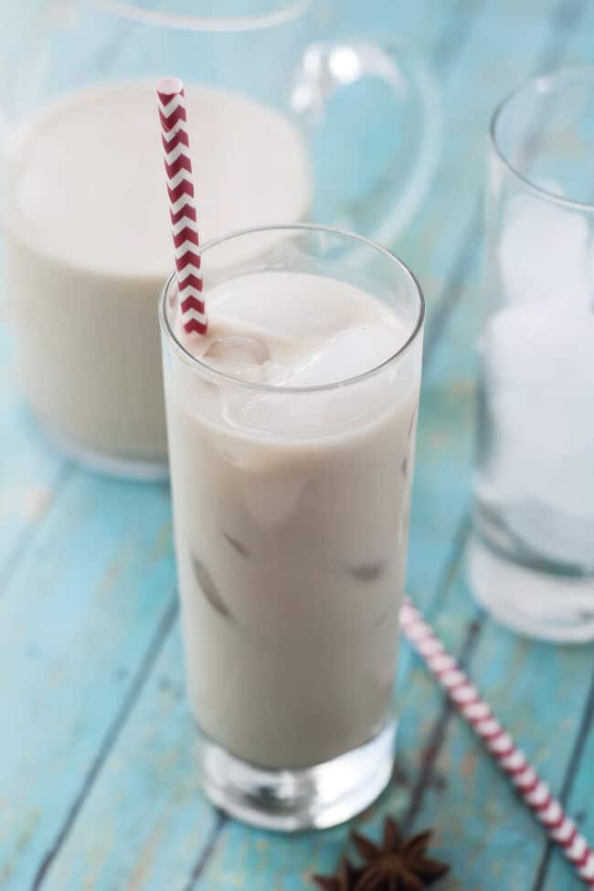 closeup of a tall glass of cashew horchata with ice and a straw
