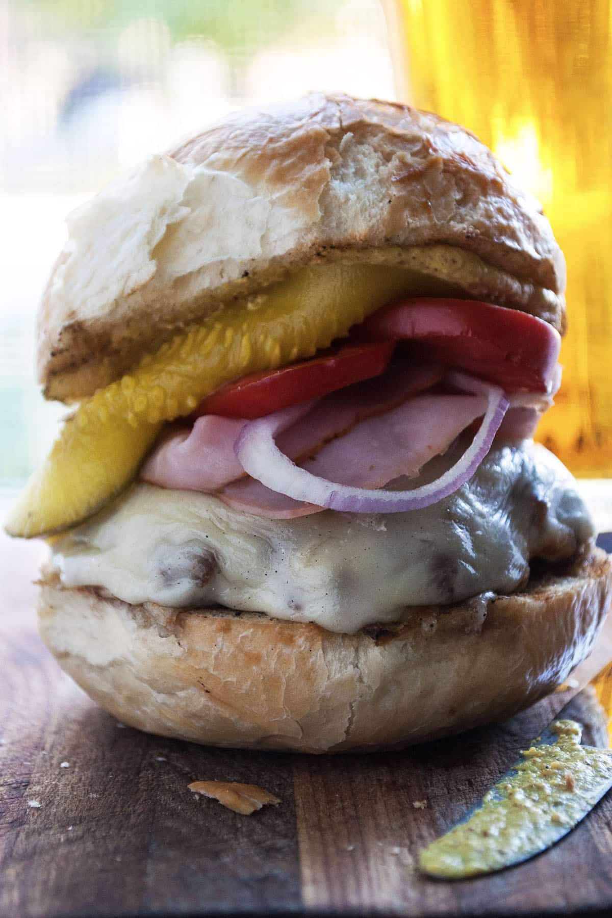 Cuban-inspired burger with layers of ham, Swiss, and dill pickles