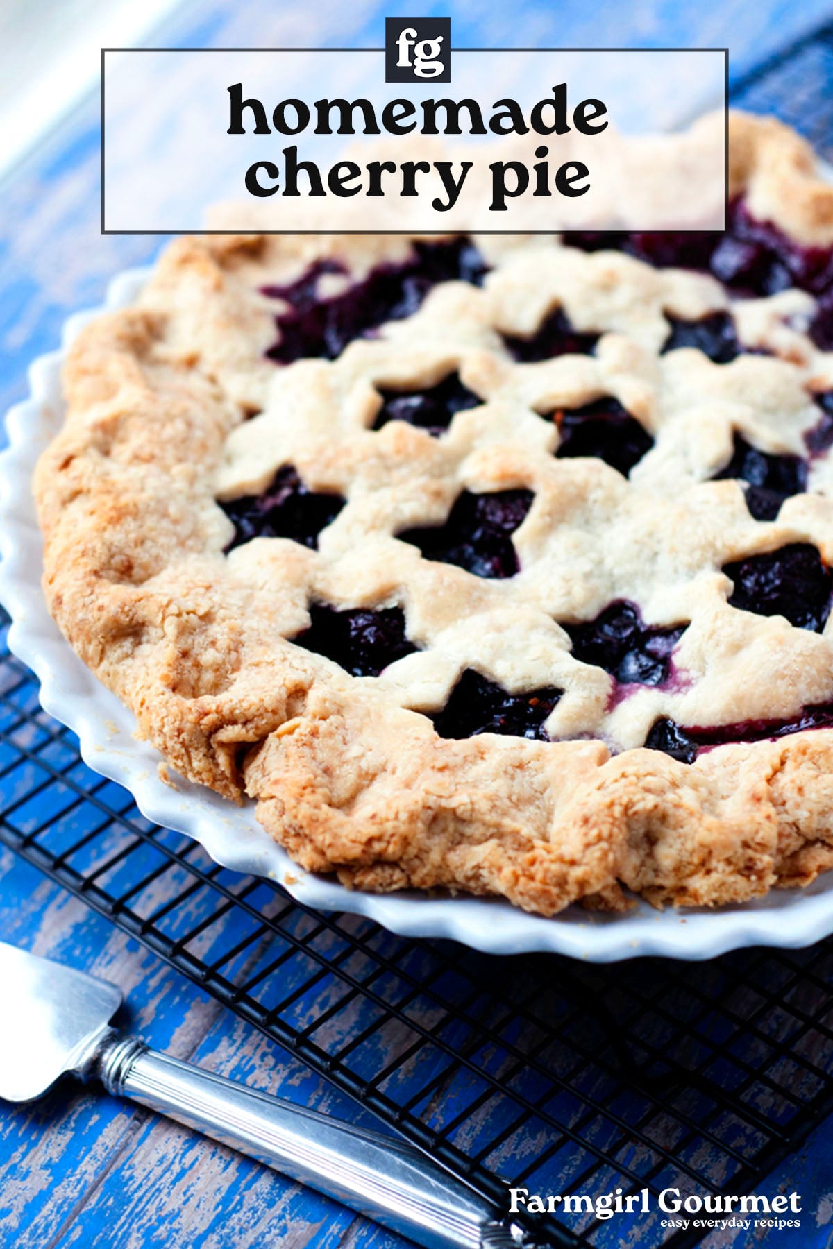 A freshly baked cherry pie with a golden, flaky crust and star-shaped cutouts on top cools on a wire rack beside a pie server. Text overlay reads homemade cherry pie.