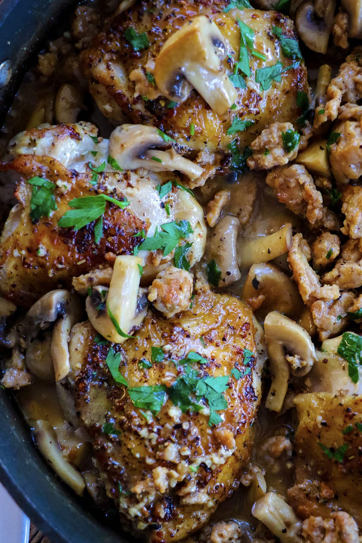 closeup of chicken thighs with mushrooms, sausage and coconut milk