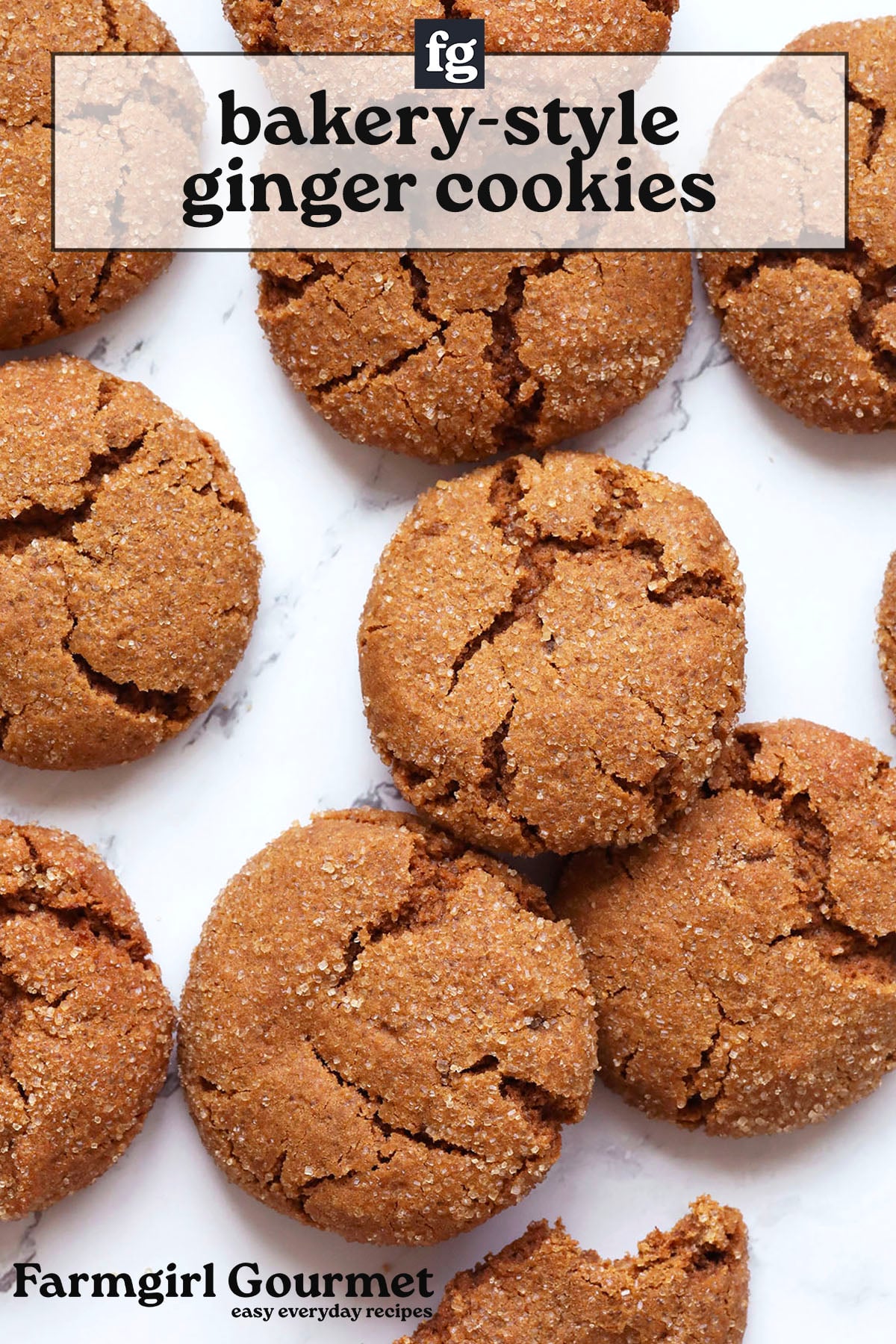 Round, golden-brown big soft ginger cookies with crackled tops are arranged on a white marble surface. The image has text overlay that reads “bakery-style ginger cookies” and “Farmgirl Gourmet easy everyday recipes.”.
