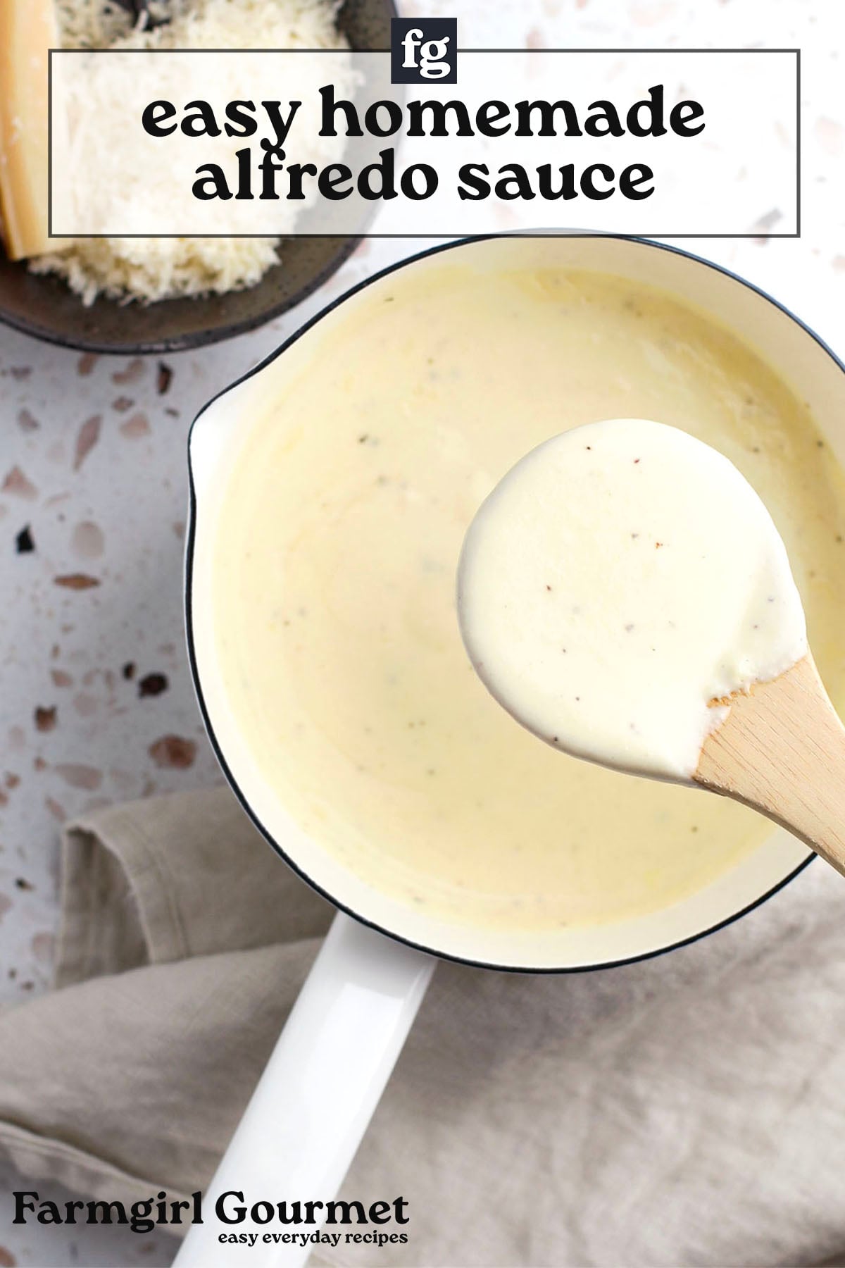A pot of creamy, homemade Alfredo sauce with a wooden spoon resting on top, sauce visible on the spoon. Grated cheese in a bowl and a cheese wedge are seen in the background. Text reads easy Alfredo sauce that doesn't break.