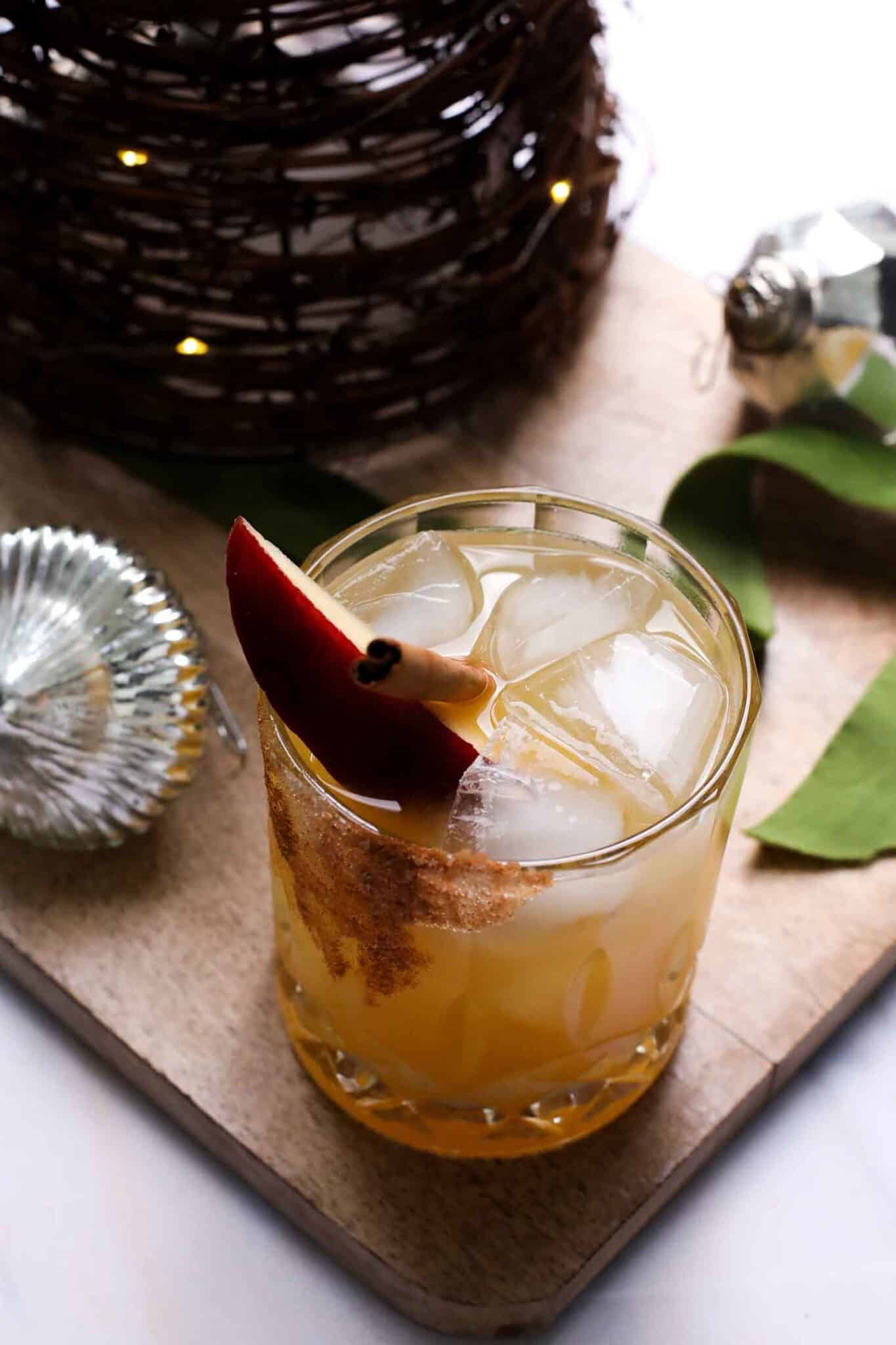 apple cider margarita with an apple wedge and cinnamon stick