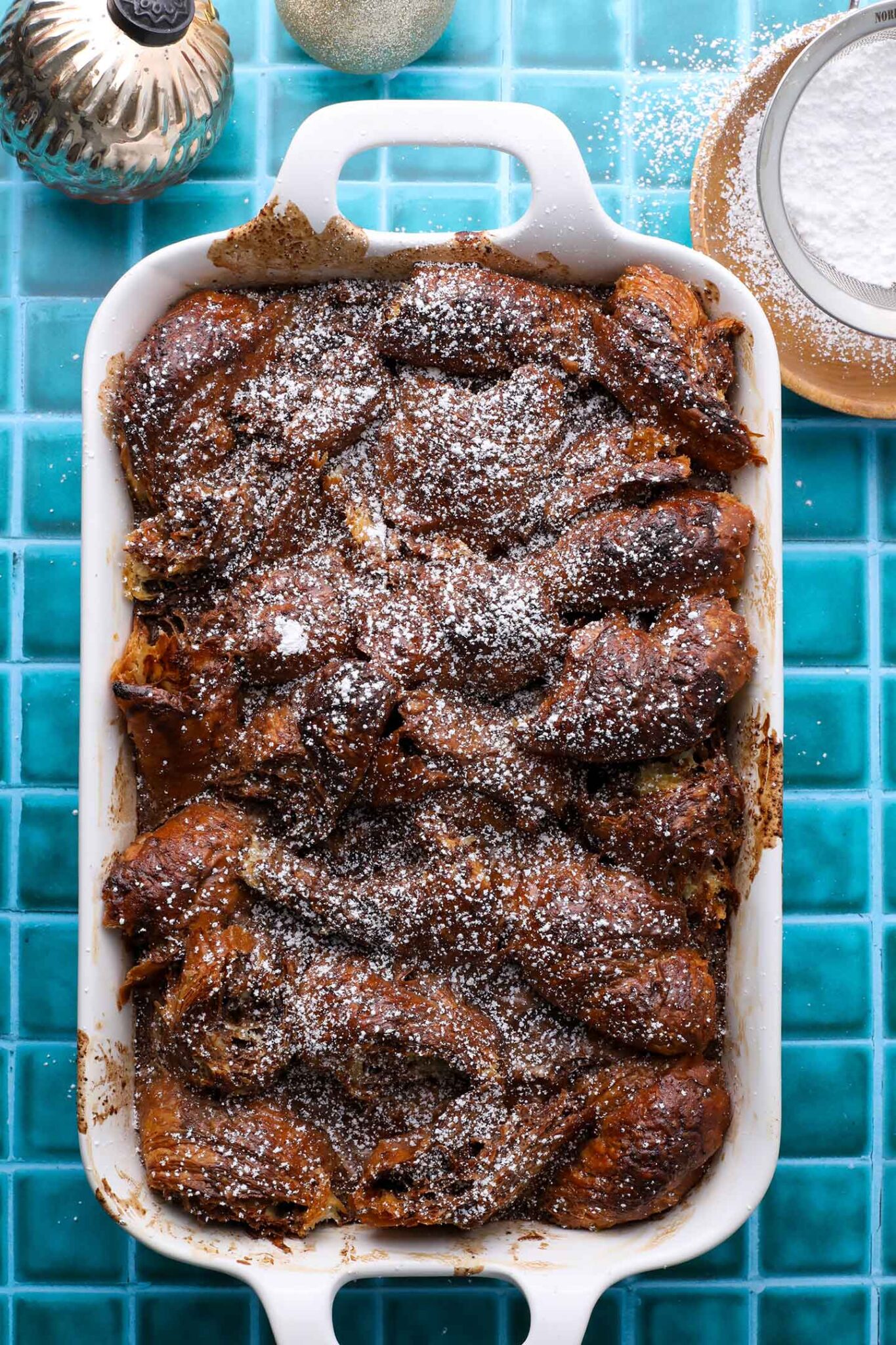 top down view of chocolate gingerbread croissant bake in a white dish