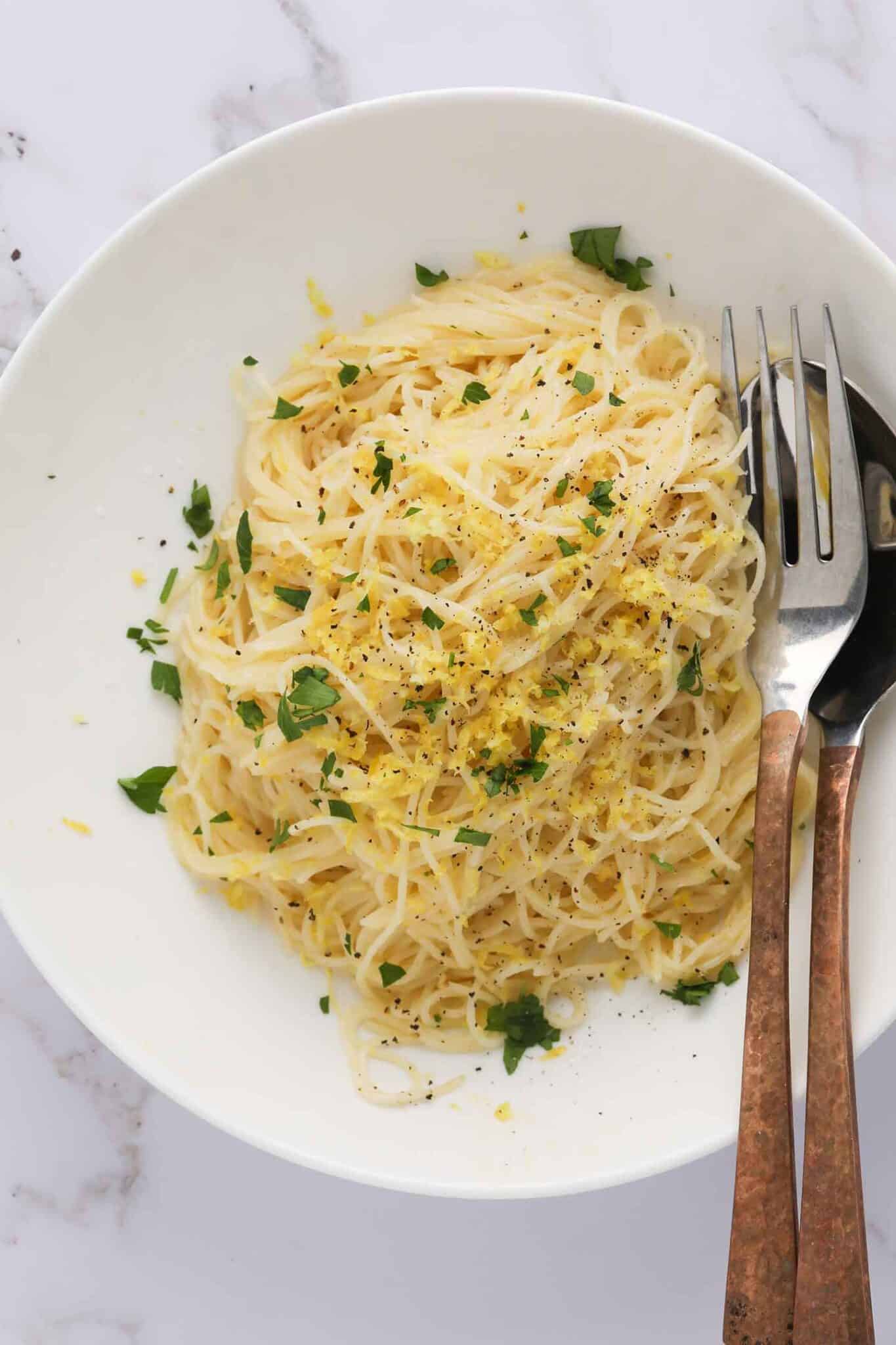 lemon capellini pasta in a bowl with silverware