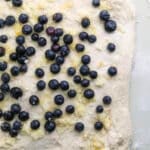 top down view of blueberries and lemon sugar on bread dough