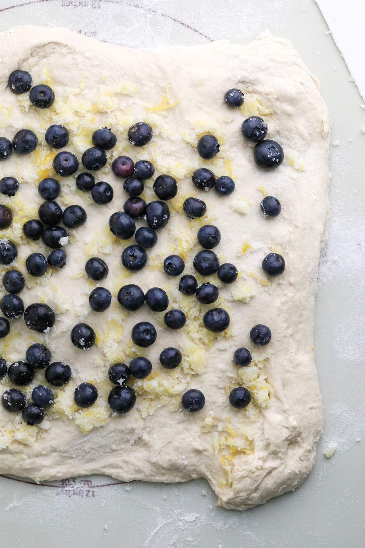 fresh blueberries and lemon sugar on bread dough
