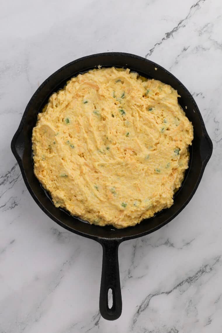 cornbread batter in a cast iron skillet ready to bake