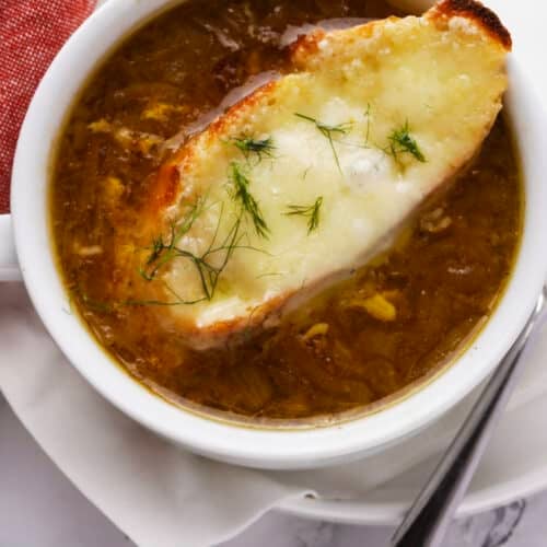 Classic French Onion Soup topped with melted Gruyere cheese and toasted baguette