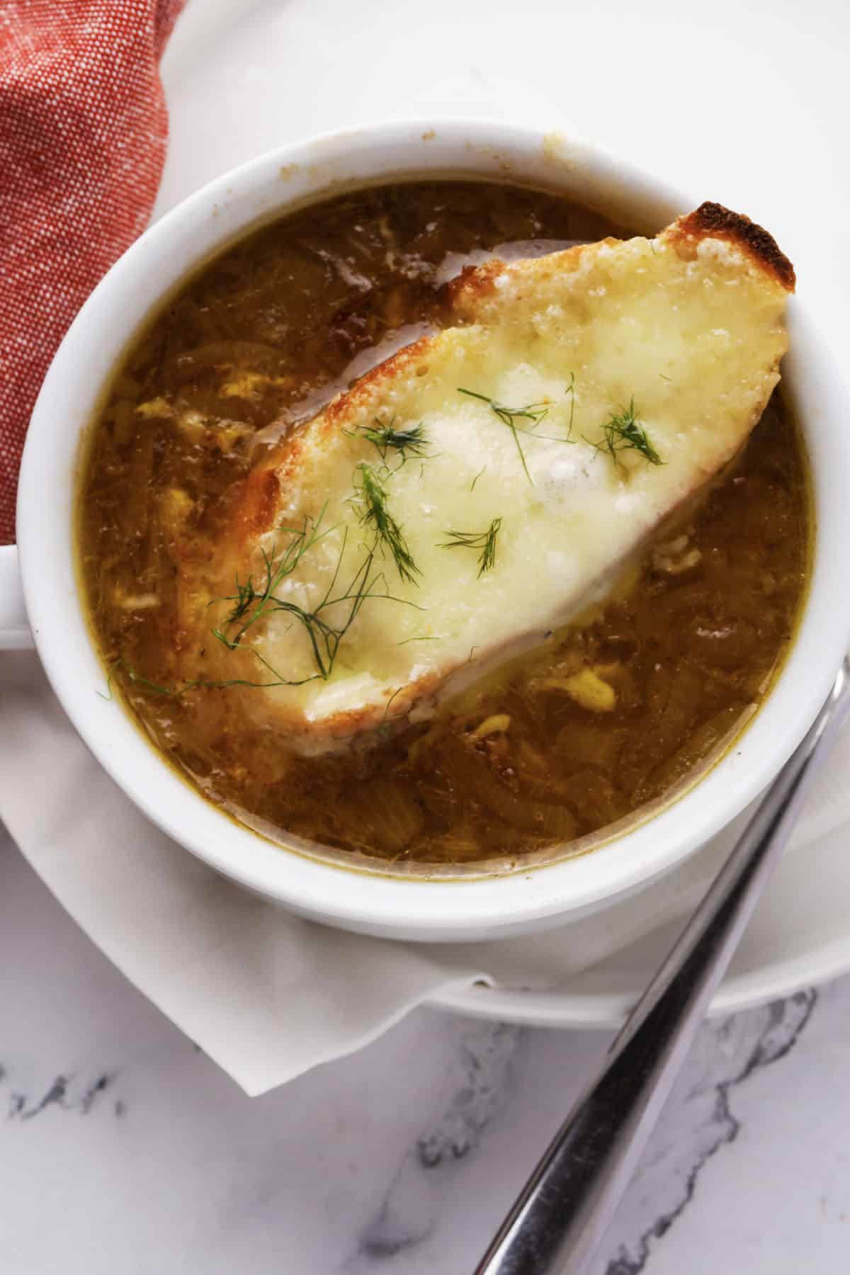 Classic French Onion Soup topped with melted Gruyere cheese and toasted French baguette