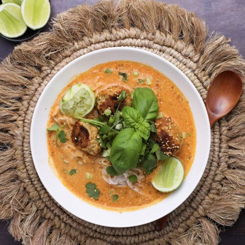 Close-up of creamy Thai-style soup with lime and sesame seeds