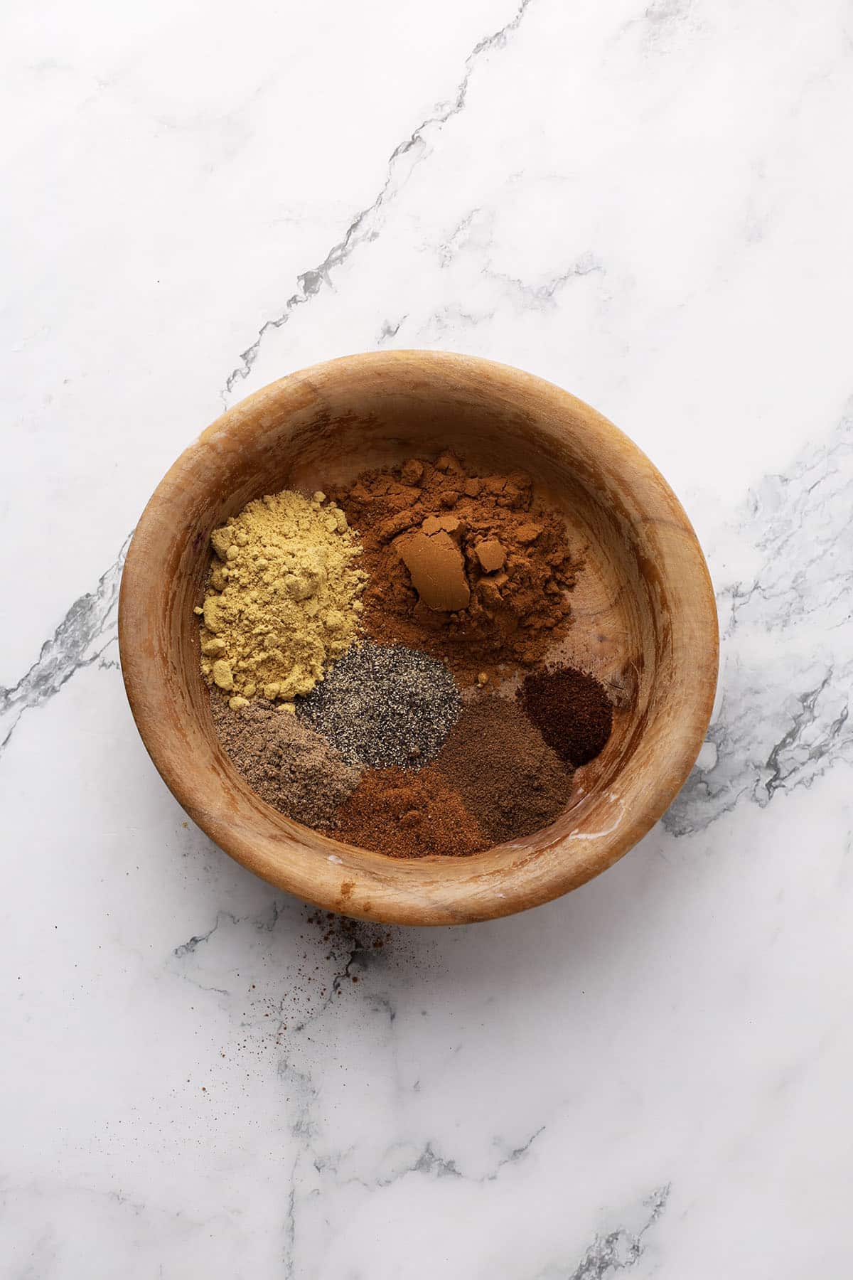 chai spice ingredients in a wooden bowl