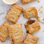 pumpkin apple turnovers with vanilla glaze on a marble background