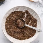 Spoon scooping Za’atar spice mix with sesame seeds visible