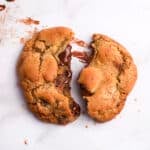 close up of a brown butter chocolate chunk cookie on a white background