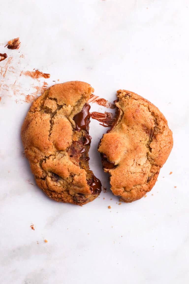 close up of a brown butter chocolate chunk cookie on a white background
