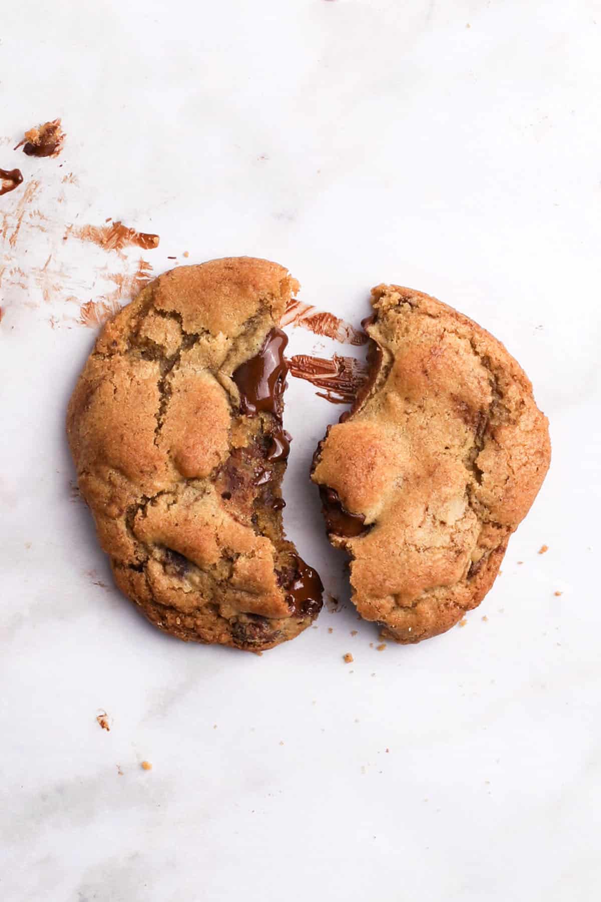 close up of a brown butter chocolate chunk cookie on a white background