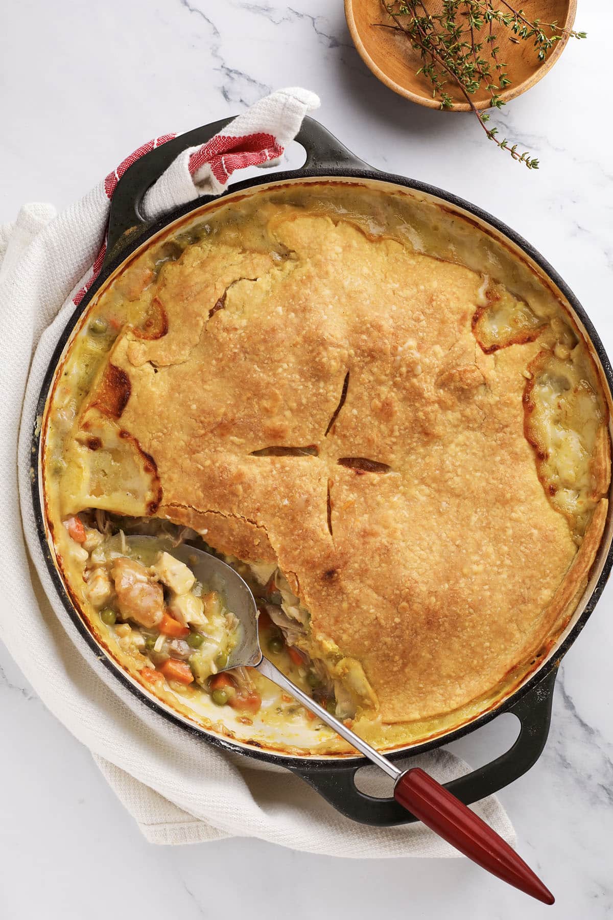 Golden turkey pot pie topped with flaky crust in a green baking dish