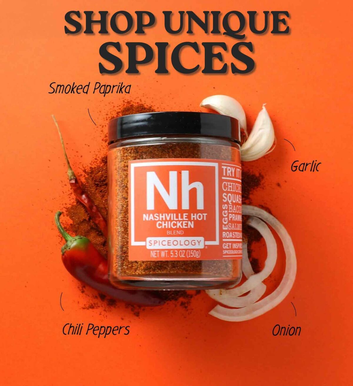 A jar of Nashville Hot Chicken spice blend sits on an orange background, surrounded by smoked paprika, garlic cloves, sliced onion, and red chili peppers, with labeled text pointing to each ingredient.