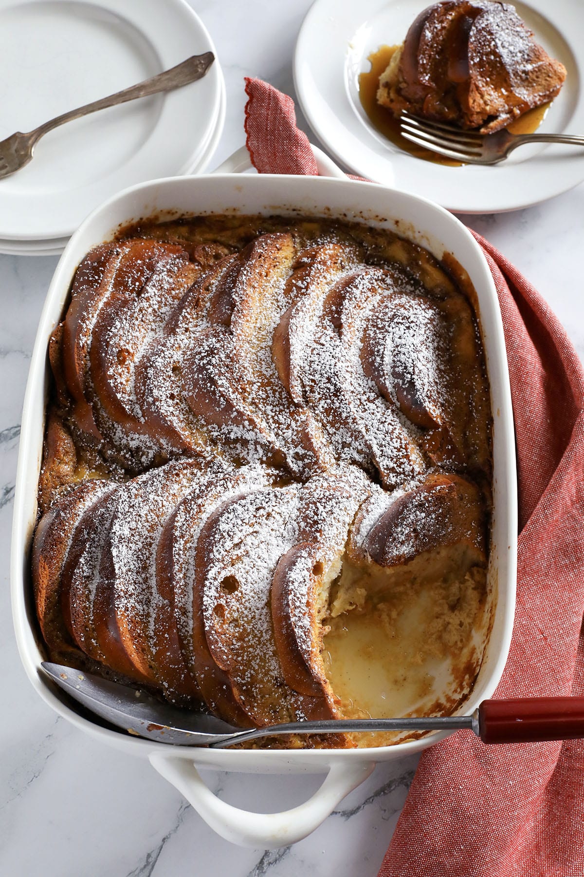 Baked challah French toast topped with powdered sugar.