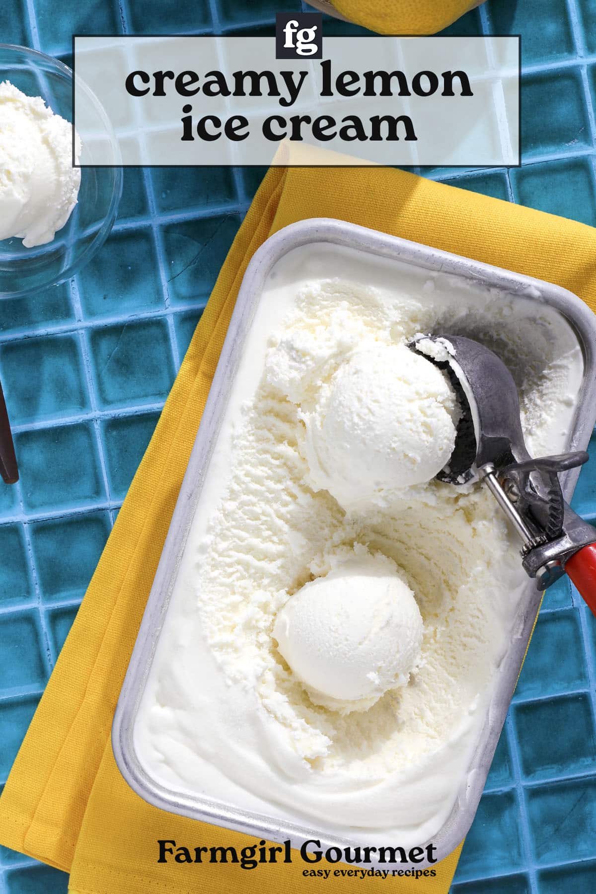 A metal container of easy lemon ice cream with two scoops, an ice cream scooper, and a yellow napkin on a blue tiled surface. Text reads creamy lemon ice cream without eggs and Farmgirl Gourmet easy everyday recipes.