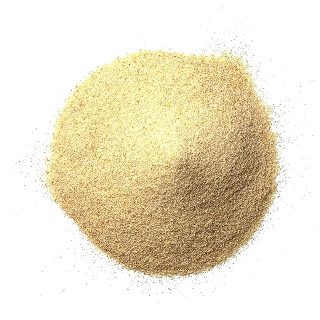 A mound of finely ground, light tan powder, spread out on a white background.