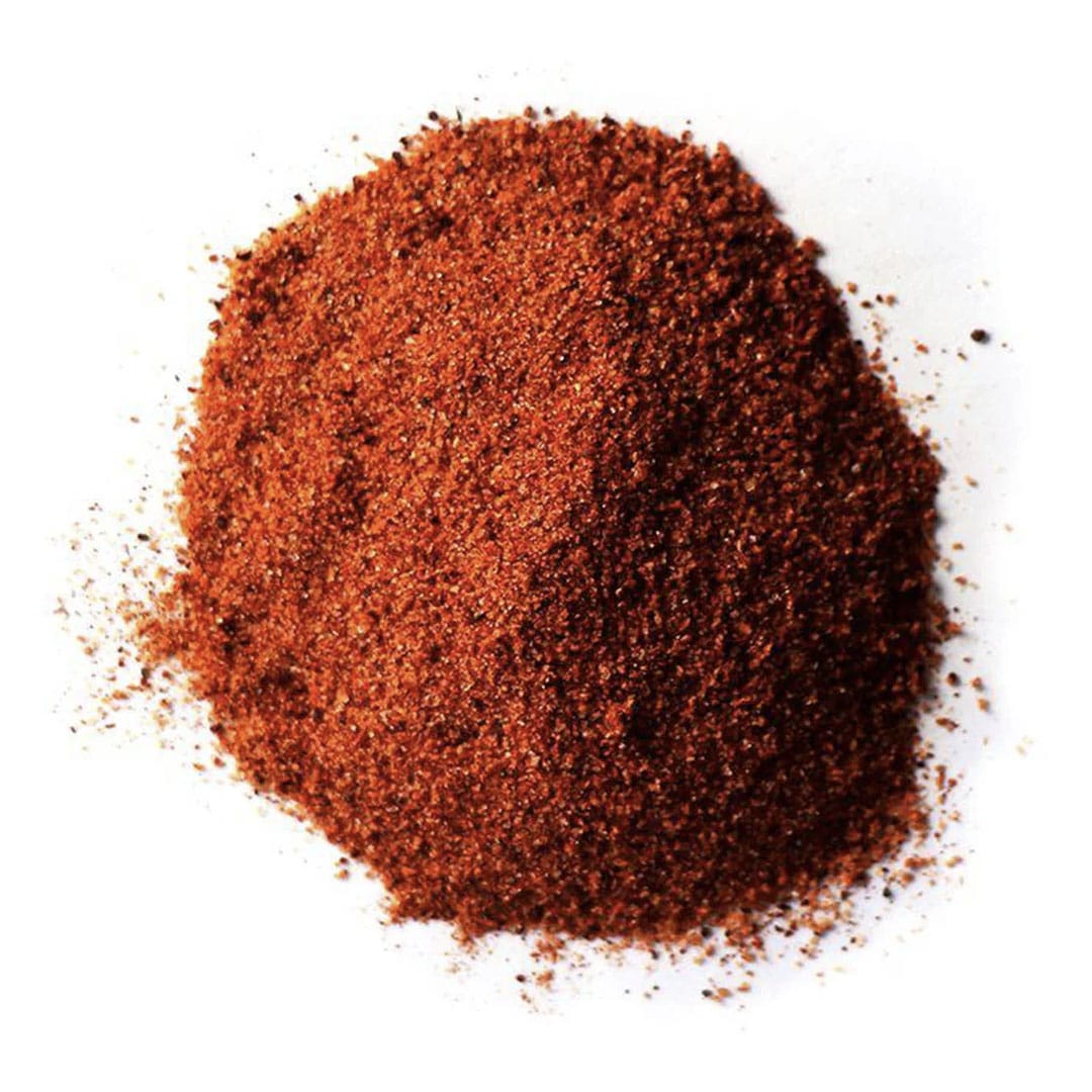 A pile of finely ground red chili powder on a white background.