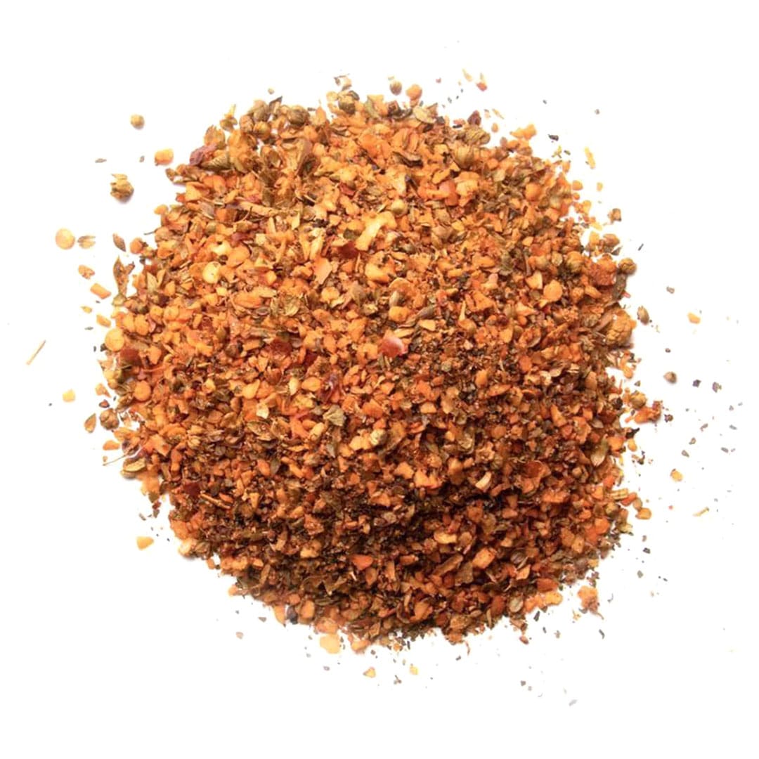 A pile of crushed red chili flakes scattered on a white background.